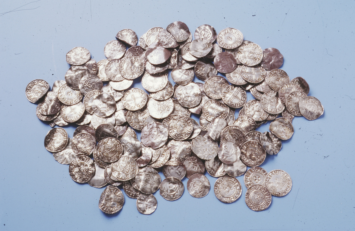 "4398. Myntfund fra vikingetiden." (160 angelsaksiske, 156 tyske og 1 kufisk mynt, dessuten 34 fragmenter av angelsaksiske og 23 fragmenter av tyske mynter. TL 2004)
