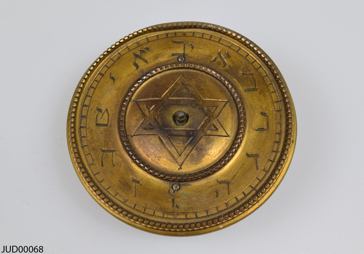 Bordsur, tillverkat av brons ståendes på en träsockel. Bordsuret är i form av två bronslejon som håller ut själva urtavlan. På urtavlan är siffrorna skrivna med hebreiska bokstäver (som har siffervärde).