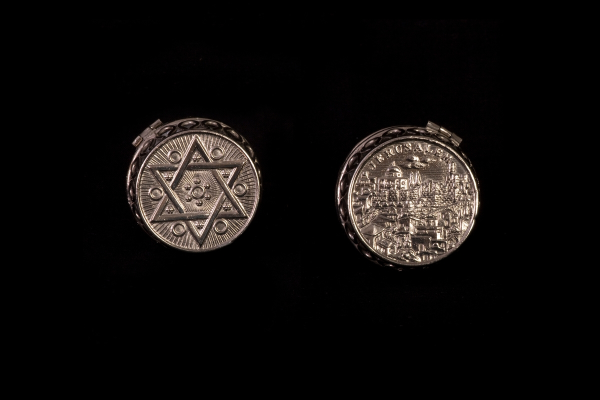 Hopfällbar ljusstake med två låga ljushållare. Ena sidan är dekorerad med en davidsstjärna medan den andra är dekorerad med en vy över Jerusalem.
