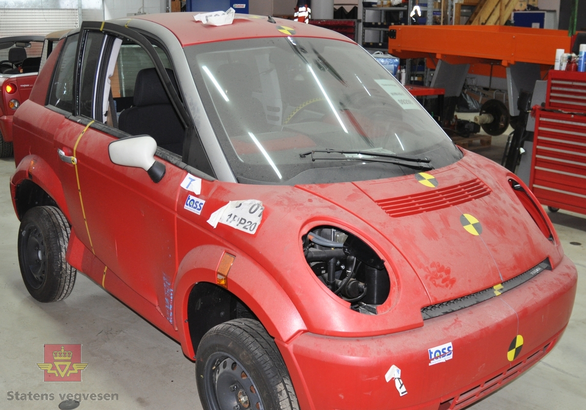 Rød elektisk drevet Think City/A306/Piv5 personbil med to sitteplasser. Bilen har et karosseri av ABS plast, underramme av stål og overramme av aluminium. Den har kollisjonsbjelker i dørene, deformasjonssoner og airbag på fører- og passasjersiden. Farget glass, sort og rødt interiør. Den har en motor på 34 kW maks effekt, og et zebrabatteri som ved en temperatur over 200 grader inneholder 25 kWh energi. Den mangler frontlykter.