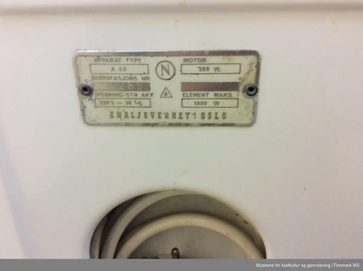 Vaskemaskinen består av en rektangulær kropp i emaljert metall.Oppe på fronten er det plassert fire brytere og en liten rød lampe. Øvresiden er laget i sølv metall. Vasketrommen er tilgjengelig fra toppen og dekket med et løst lokk med en rundt, blått håndtak i midten. Oppe på vaskemaskinen, i bakre, venstre hjørnet, er det montert en vrimaskin eller klesrulle. Den kan høydejusteres ved å vri mekanismen på øvresiden der det står LOW, MED og HIGH. På høyresiden av klesrullemekanismen finnes det et lås som kan åpnes ved å løfte den. Den øvre avdekningen kan løftes og rullene kan tas ut. På vaskemaskinens bakside er typeskiltet plassert og det finnes et lite rom med rund åpning, der den elektriske ledningen kan plasseres.