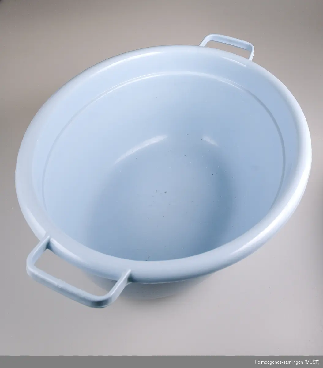 Lysblå oval vaskebalje av plast med to håndtak.