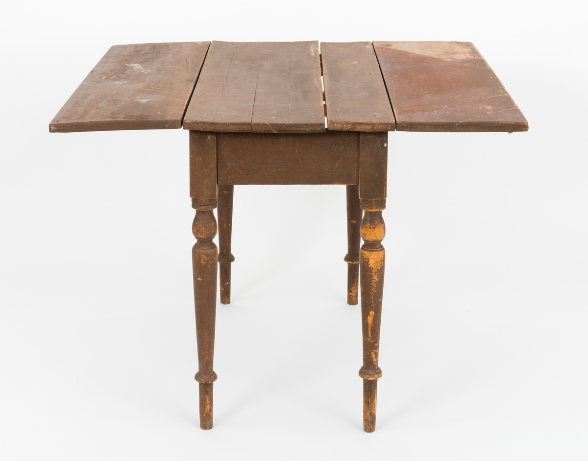 Bord, klaffebord, av furu med rektangulær bordplate.  Bordet har bred klaff på hver langside. 
I den ene tverrenden har det vært en skuff, men den mangler. 
Bordplata er sammensatt av tre bord, klaffene av ett bredt bord. Bordet har fire dreide ben.