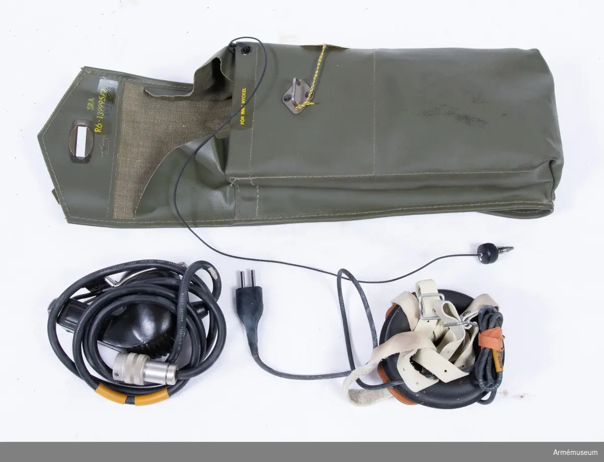 Packficka av grön galonväv. I packfickan: antennsladd, förlängningssladd, hörlur, isärtagbar telefonlur.