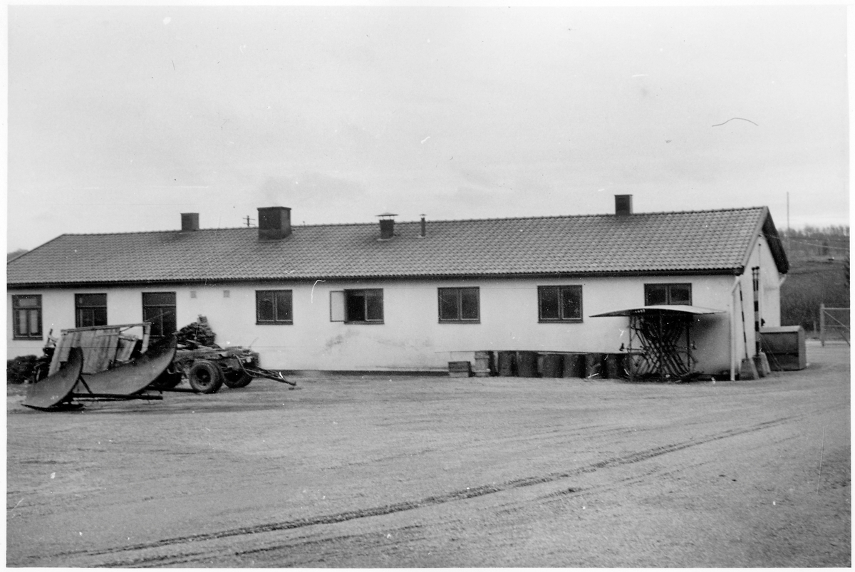 Vägstation P14, Färgelanda. Vägstationens huvudbyggnad (baksidan) med från vänster verkstad, kontor, garage. På garageplan sidoplogar, släpkärra till lastbil, cykelställ med cyklar.