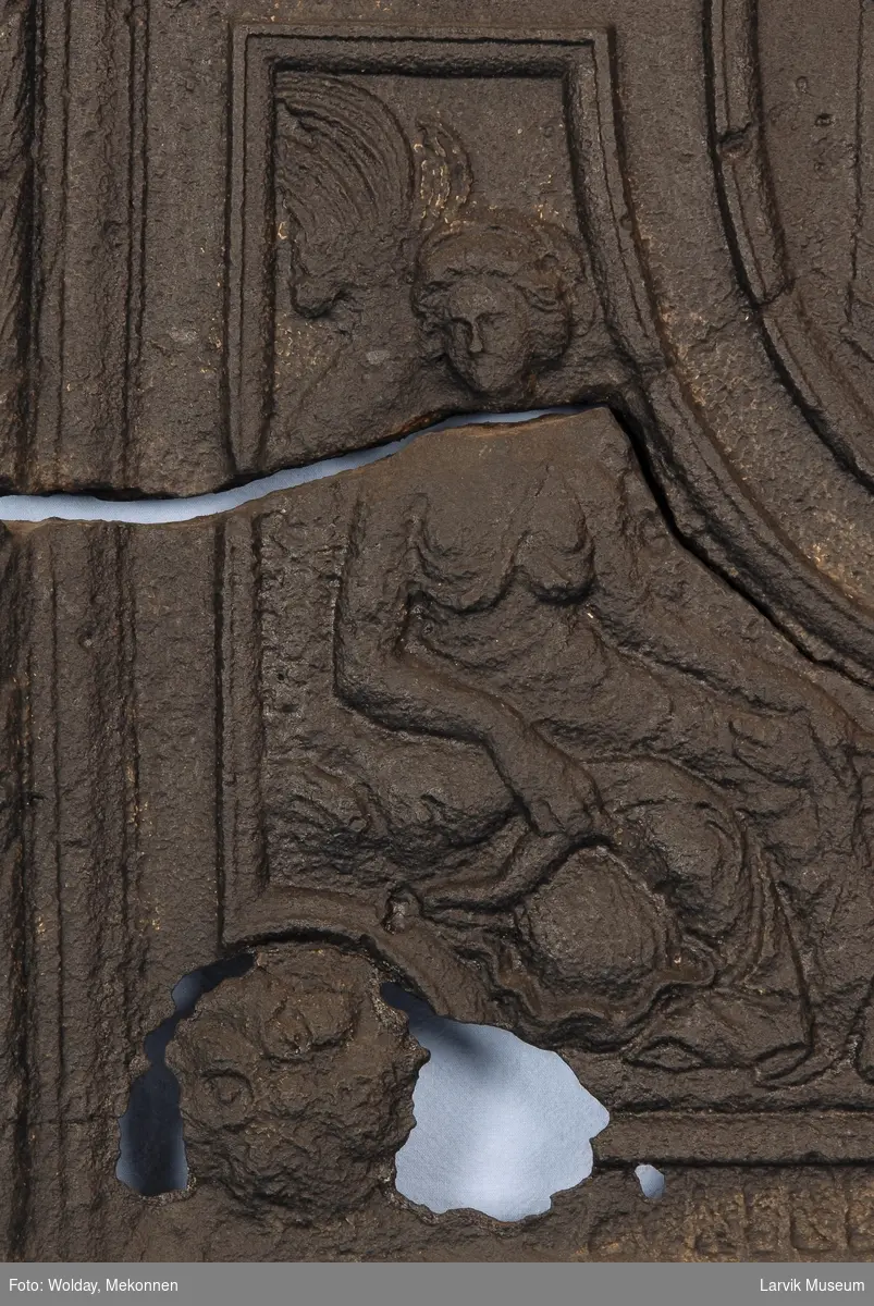 De 4 elementer fremstilt ved fire allegoriske kvinnefigurer i hvert sitt felt. I midten ovalt felt med brennende alter i tempel. I hvert hjørne en rosett. På begge sider flat ramme med regenceornamentikk.