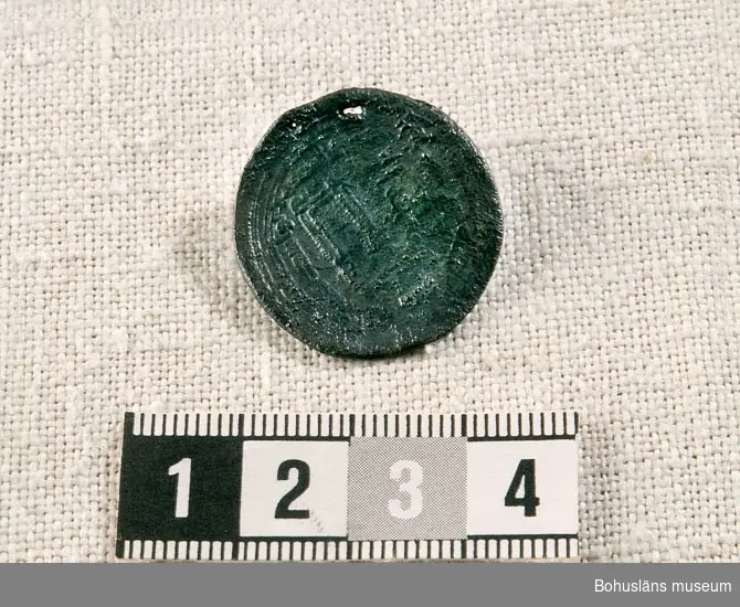 Myntet genomborrat av ett litet hål (för upphängning?) använt som smycke? Myntet daterat till år 743 e. Kr.