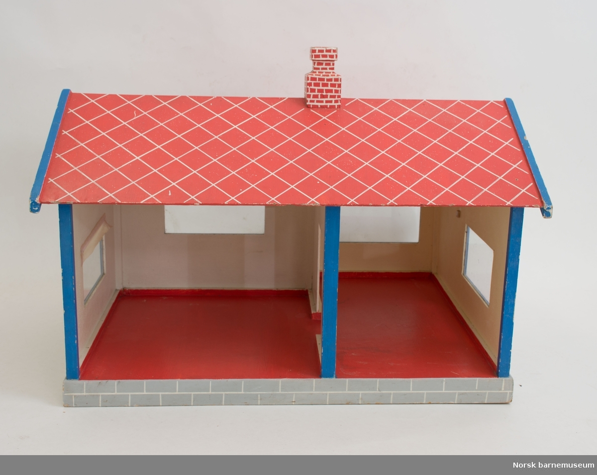 Dukkehuset er utformet som funkishus og har 2 store rom. Taket er skrått med pipe. Taket er malt rødt, med hvite streker som skal symbolisere takpanner. Veggene er hvite, med blåmalte lister rundt de fire vinduene. 