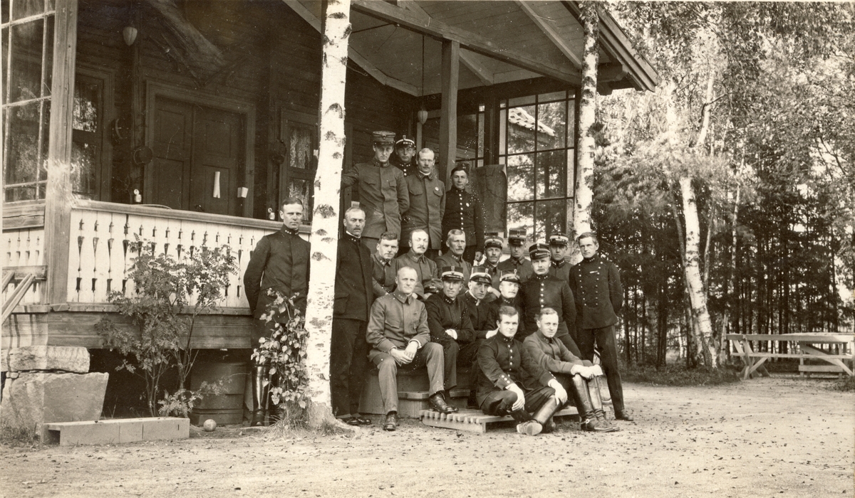 Gruppebilde av antagelig lærere og elever foran veranda ved Infanteriets Skyteskole på Terningmoen i Elverum, Hedmark. Fotografert 1918.