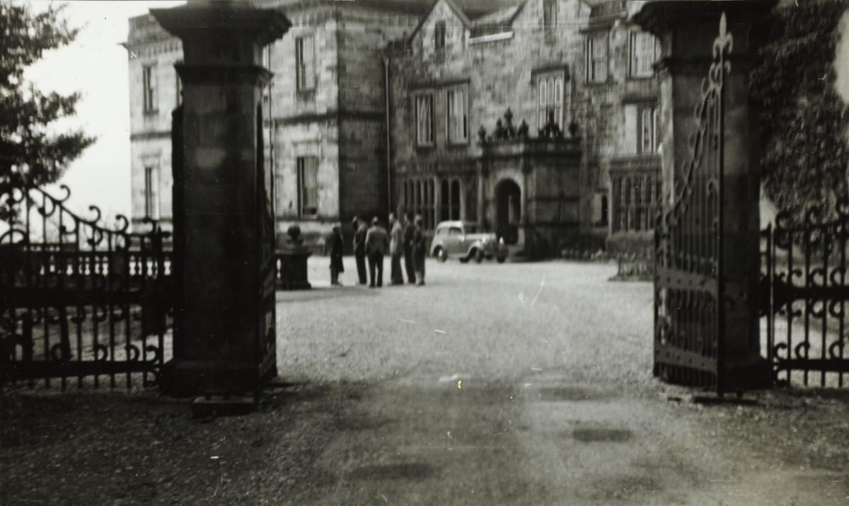 Fearnley Hall på ukjent sted i Storbritannia. En gruppe menn står på gårdsplassen og en bil er parkert foran inngangen.Fotografert i mai 1951.