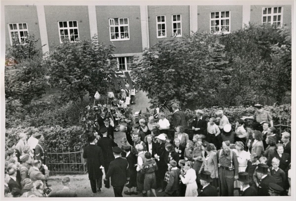 Den 22. august 1945 kom kong Haakon VII på besøk til Haugesund. Han tok seg også tid til å besøke Sjømennenes Aldershjem på Hasseløy. Tilskuere i finstas og med norske flagg har stilt seg opp langs veien inn til Aldershjemmet.