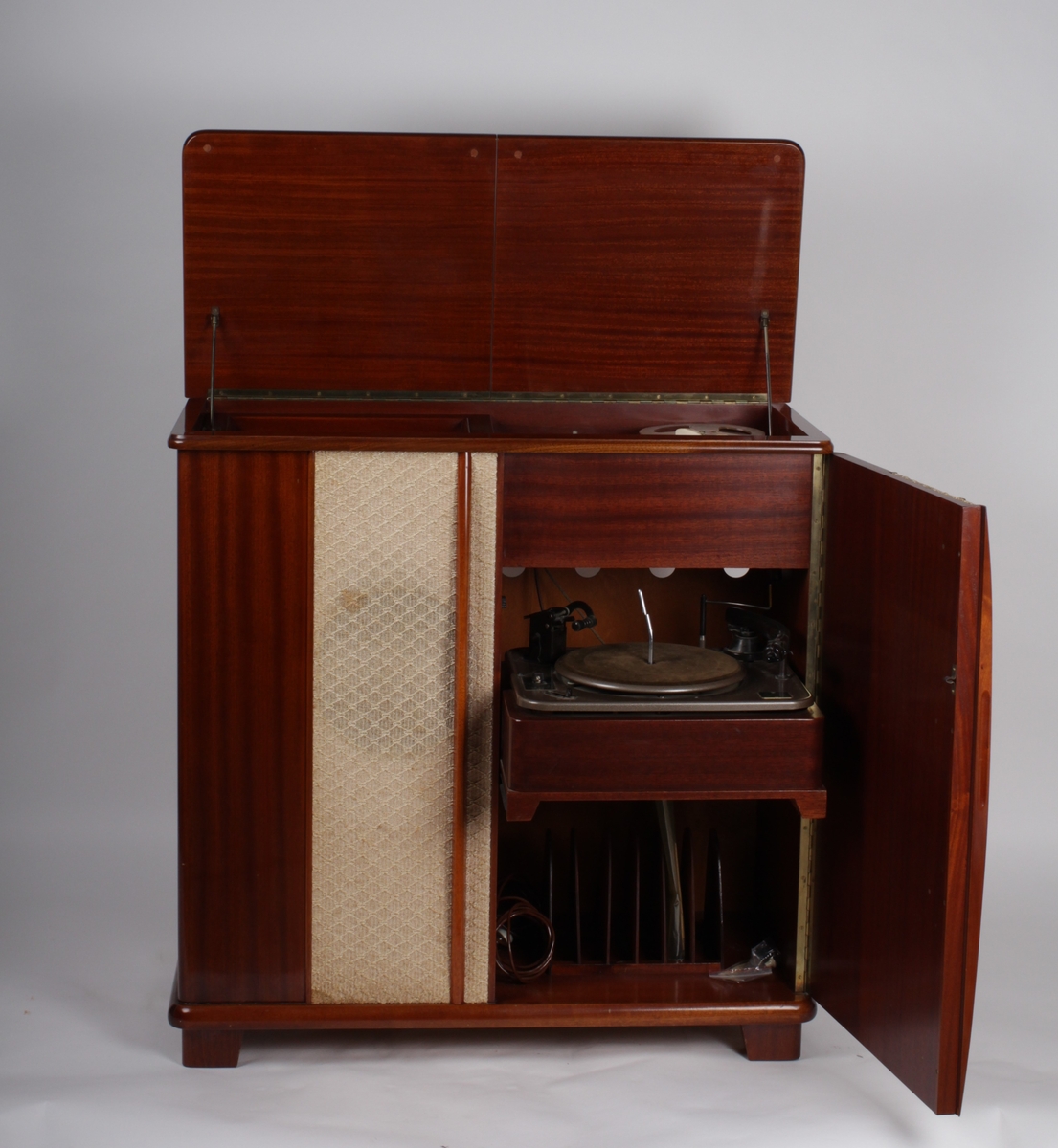 Radionette studio radio-grammofon med båndopptaker. I tre med tekstilfront. Grammofon under toppplate