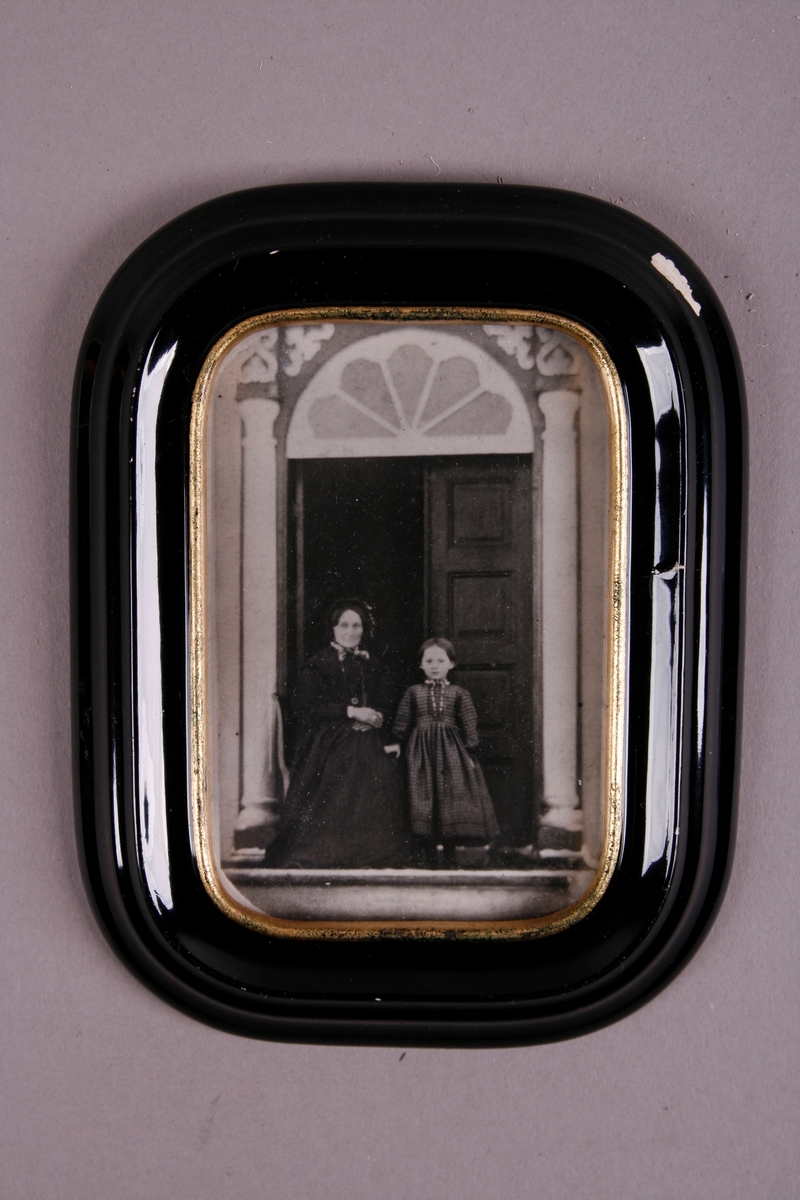 Kvinne og barn fotografert i døråpning.