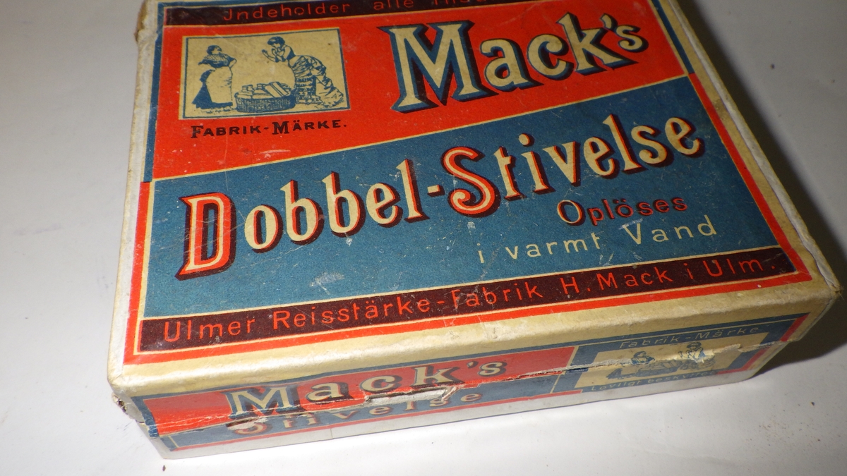 Eske til stivelse.
papp, hvit, merkelapp i rødt, blått, sort
dekker lokk og to sider .
mrk . lokk: "Macks ' Dobbel- Stivelse"
"opløses i varmt vand."
"Ulmer Reisstärk, -Fabrik H.Mack i Ulm ."
fabrikkmerke på 3 steder viser :
to damer og en kleskurv m/ klær
hvit m/ blått trykk .