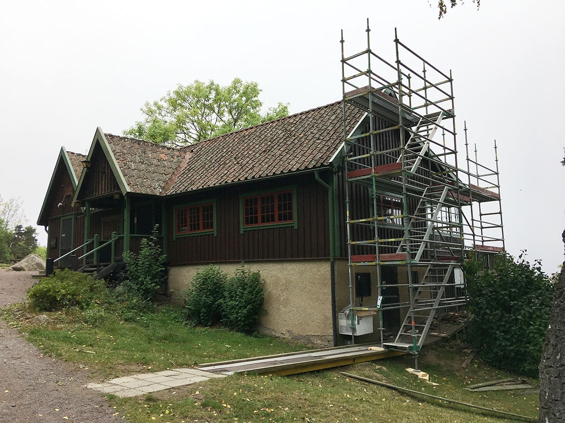 Renovering av Kaffestugan på Grännaberget. En byggnadsställning är rest mot norra gaveln som ska målas