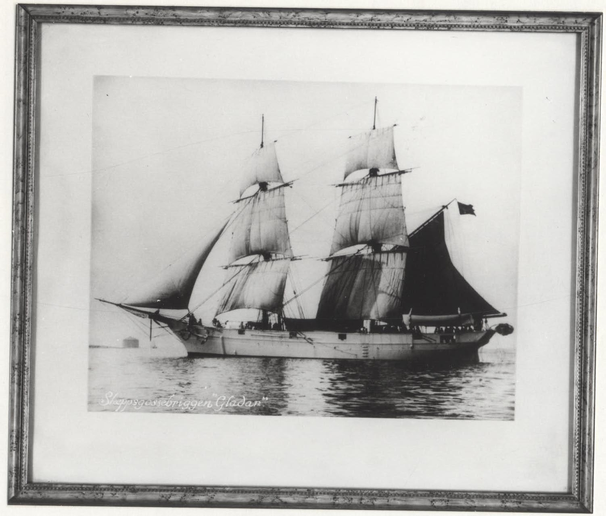 Inramat s/v fotografi av skeppet GLADAN avbildan från babords sida.
