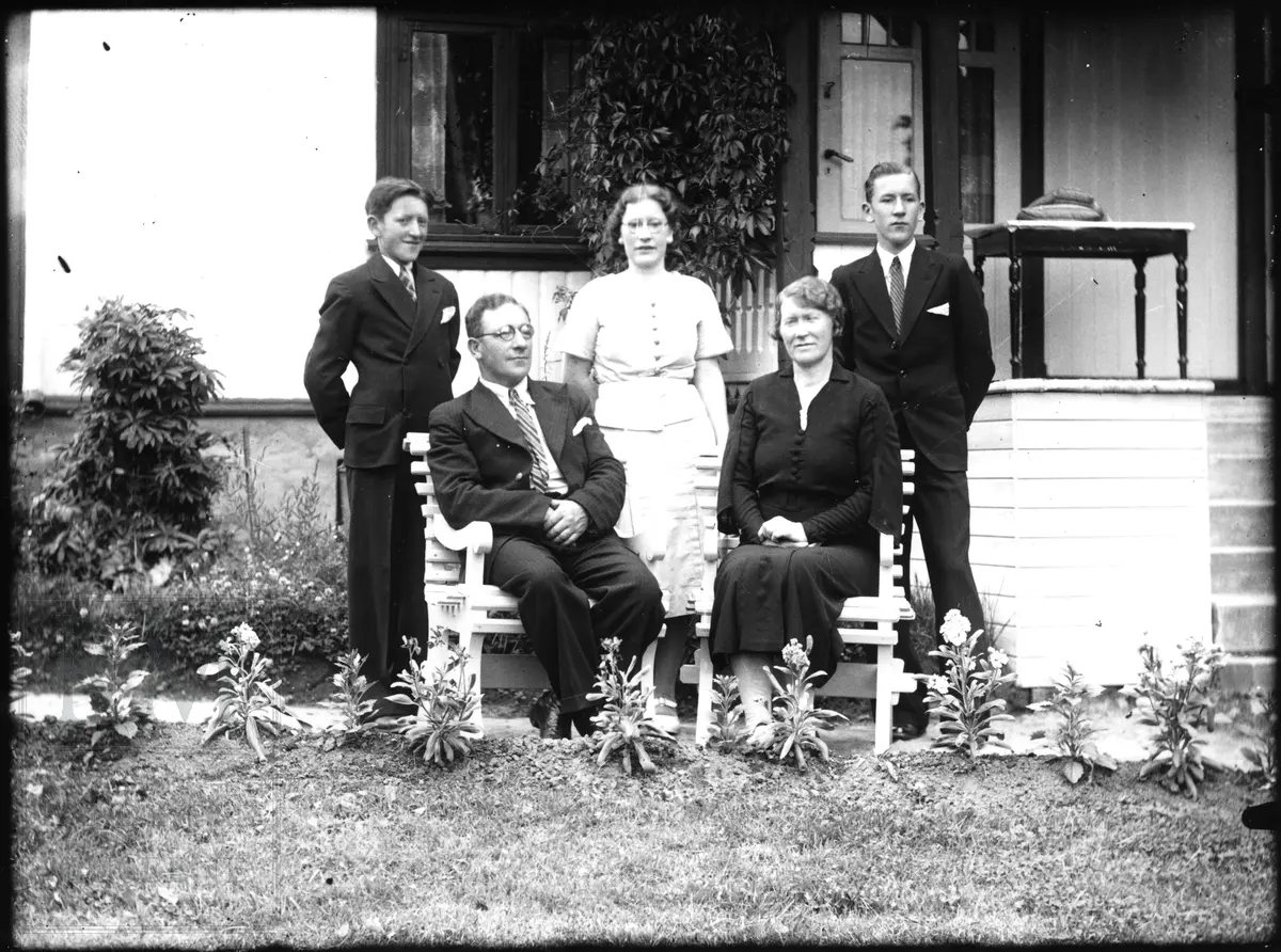 Familie Nicolaysen samlet utenfor et hus, foreldre og tre barn.