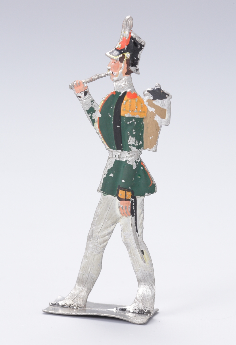 Flöjtblåsare, del av en militär musikkår. Uniform i grönt och vitt av sent 1800-talssnitt.
Inskrivet i huvudbok 1937.