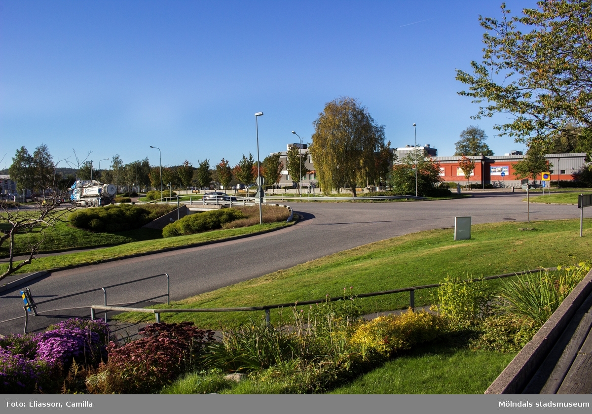 Vy mot sydväst från Församlingscentrum Lindome med adress Annestorpsvägen 1 i Annestorp, Lindome, den 4 oktober 2016. Till vänster skymtas Valåsvägens mynning i Industrivägen. Närmast ses Annestorpsvägens mynning i Valåsvägen samt en gång- och cykeltunnel som går under Valåsvägen. I bakgrunden ses affärsbyggnader vid Almåsgången i Lindome centrum.