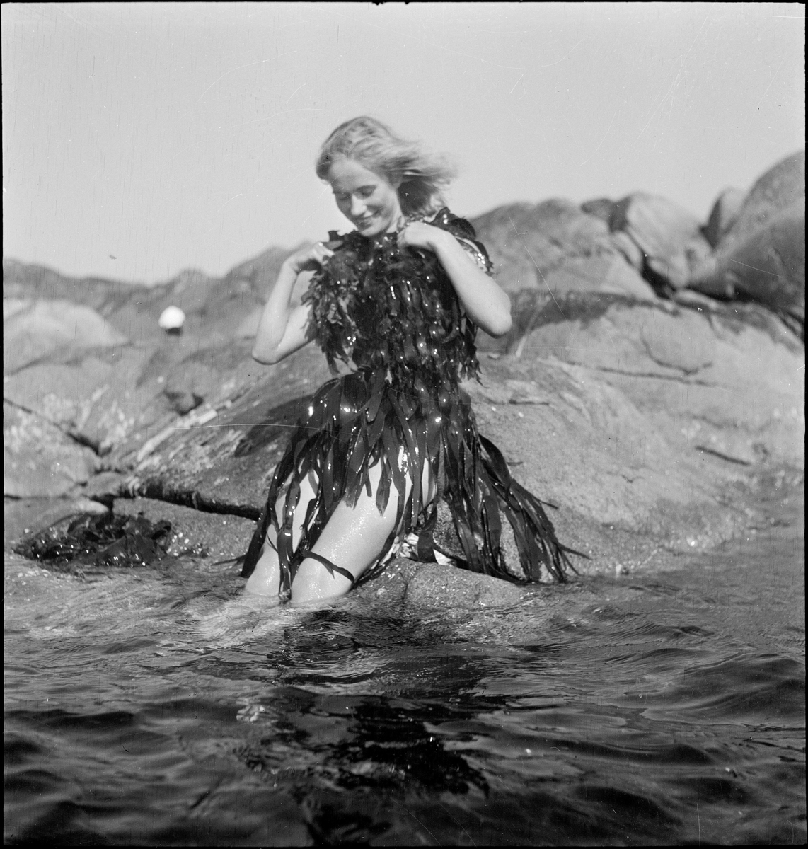 Frøken Andreassen kledd som "Fruen fra havet", med en kjole av tare.