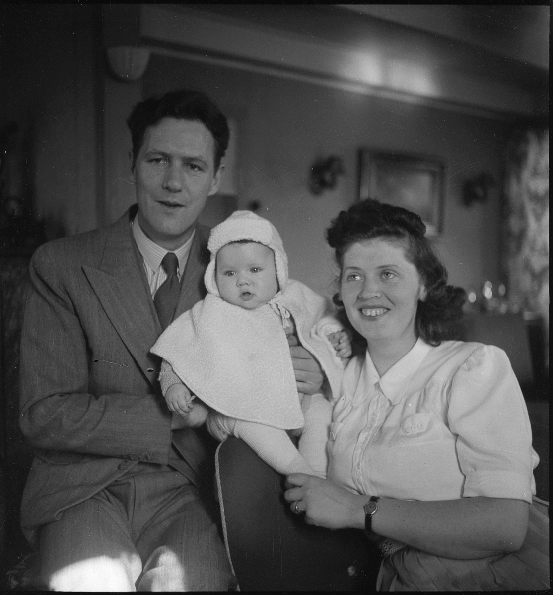 Portrett av en liten familie, med far, mor og en liten baby.