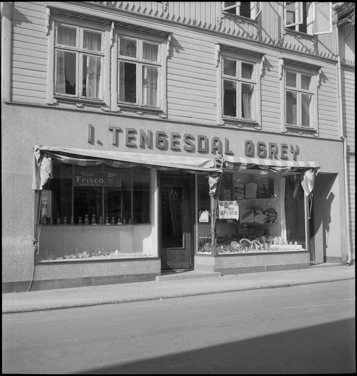 Kjøkkenbutikken "I. Tengesdal Øgrey" i Egersund. Det er glass, keramikk, serveringsfat og flagg i utstillingsviduene.