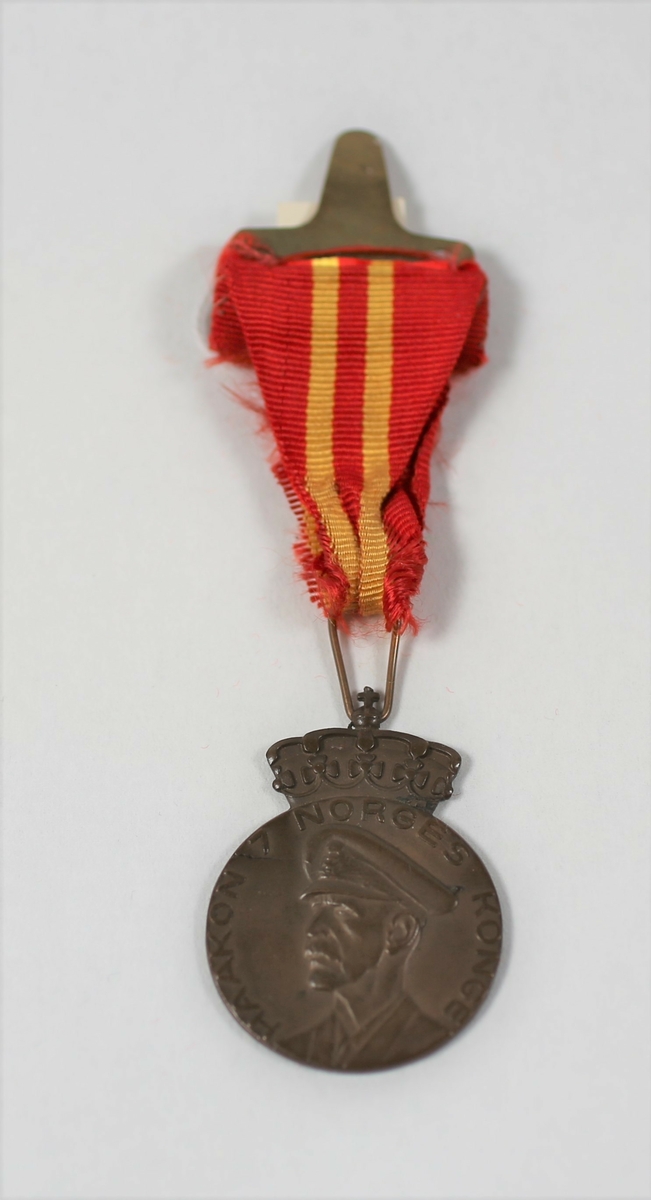 Medalje i bronse, på advers med omskriften "*HAAKON 7 NORGES KONGE". På reversen er innskriften «TIL MINNE OM 70 ÅRSDAGEN 3 AUGUST 1942». Motivet er omgitt av en lenke. Båndet er delvis i dårlig forfatning.