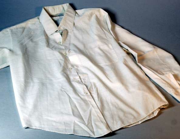 Skjorta av vit bomull och polyester. Långa ärmar. Bröstficka. Hål för manschettknappar. Märkt: Diolen COTTON, POLYESTER FIBRE + 33% COTTON.
