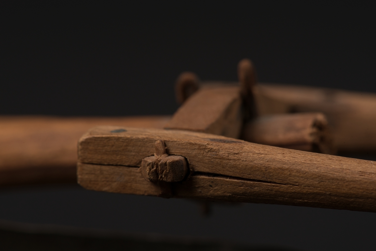 Modell av plog tillverkad av trä, delvis furu. Billen och vändskivan är tillverkade av bleckplåt.