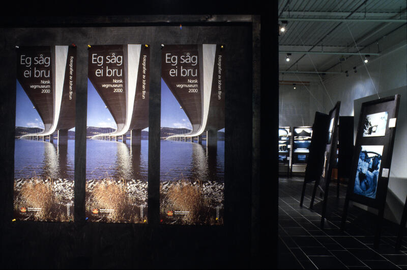 Oversiktsbilde over utstillingen "Eg såg ei bru". Mange sorte stativer med fotografier av bruer.