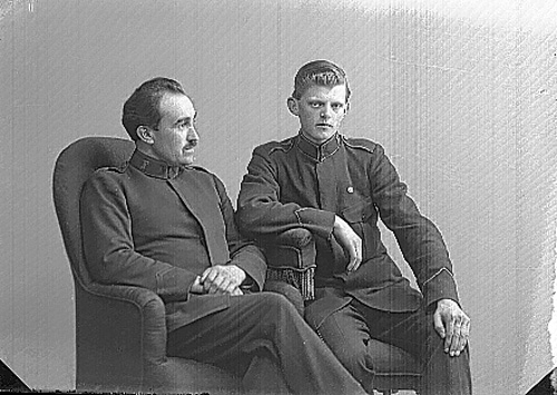 Två män i Frälsningsarméns uniform sitter i varsin fåtölj.