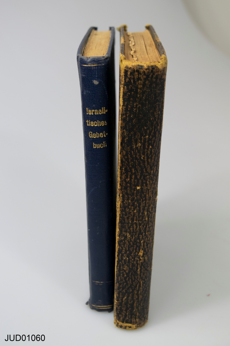 Två bönböcker på hebreiska och tyska, en med blå pärm, en med brun.