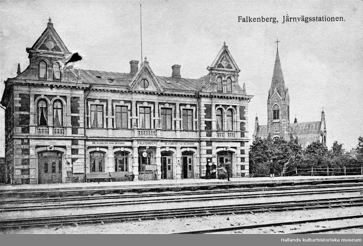 Vykort, "Falkenberg. Järnvägsstationen". Till höger ses stadens moderna kyrka från 1892. På stationshusen angavs ofta avstånd till andra orter. Här upplyses resenärerna om att de är 108 km från Göteborg och 136 km från Helsingborg.