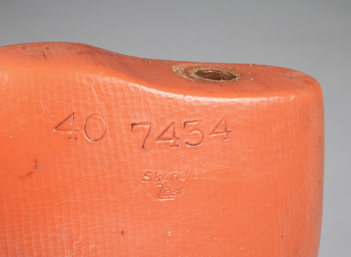 Skoläst i orangefärgad komposit. Bakparti upptill med infälld cylinder. Märkt: Skandia läst, 40 7434. Medföljer ofärdig sandal, med två kardborre-remmar och sula i svart skinn. Sulan märkt i guld: "Wiskania GOLDEN SOFT SVENSK TILLVERKNING 40"

En läst är en form som används vid tillverkning av skor. Den var förr tillverkad av trä för olika storlekar och för vänster- respektive högerskor. Lästerna kan också ha olika utföranden för dam- och herrskor, för olika typer av skor och för olika fötter (till exempel breda och smala).
För industriell tillverkning av skor är lästerna numera vanligen tillverkade i plast eller metall. (Wikipedia)

Historik: 
N.H Ljungberg startade år 1903 en läderaffär på Allégatan i Borås och företaget utvidgades och kom även omfatta partiförsäljning av skodon och galoscher. År 1916 startade Ljungberg läderfabriken vid Gässlösavägen. Fabrikens produktion bestod till en början huvudsakligen av bottenläder men utökades senare till att även innefatta diverse ovanläder och sulläder. Under 1940-talet bildades ett antal dotterbolag till företaget för tillverkning av skor och tofflor. Vid den här tiden fanns det 75 anställda vid fabriken i Borås. Samtliga bolag som var knutna till fabriken samlades senare under företagsnamnet Wiskaniabolagen. År 1969 ingick AB Ljungbergs läderfabrik, AB Ljungbergia, Sko AB Wiskania samt försäljningsbolaget Wiskania AB i bolaget. År 1972 blev Wiskania Sko AB löntagarägt, av drygt 100 anställda gick 92 personer in och blev delägare i bolaget. Verksamheten vid Wiskania Sko AB lades ner under 1991.

En storsäljare ända in i nutid, var skor i allmogestil till folkdans och dylikt.