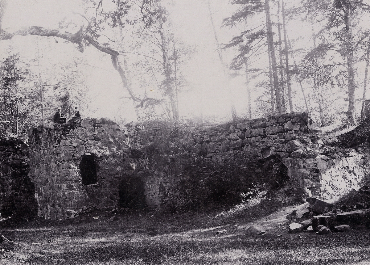 Kronobergs slottsruin, borggården. En man och en kvinna har slagit sig ner på ruinen av det sydvästra trapphuset. Längst till höger i bilden syns den nedrasade, västra porten. Foto mot SV, 1890-tal.