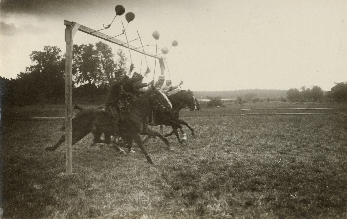 Soldater till häst rider över övningsfält.
