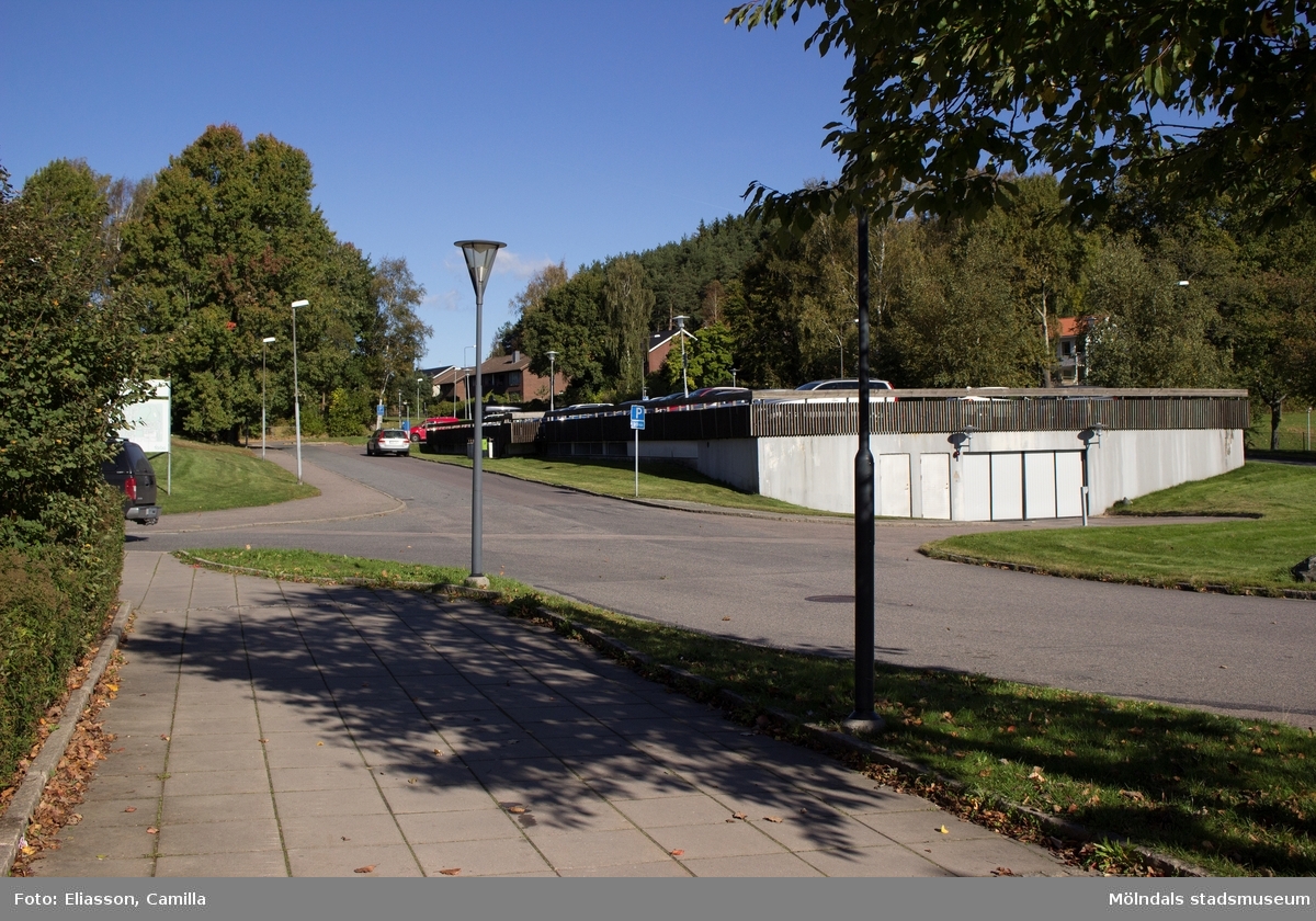 Parkeringsgarage i anslutning till bostadsbebyggelsen i Smörkullegården, Lindome, den 4 oktober 2016. I bakgrunden ses även ett par bostadshus vid Gråstensvägen. Vy mot nordost.
