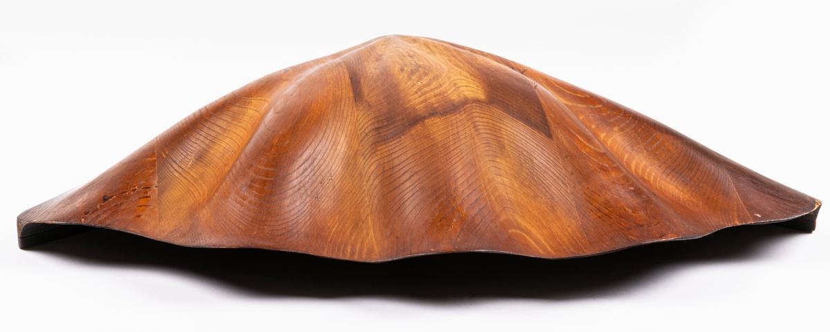 Vägglampa av furuträ skuren i ett stycke i form av mussla formgiven av konstnär Johnny Mattsson, Gävle.