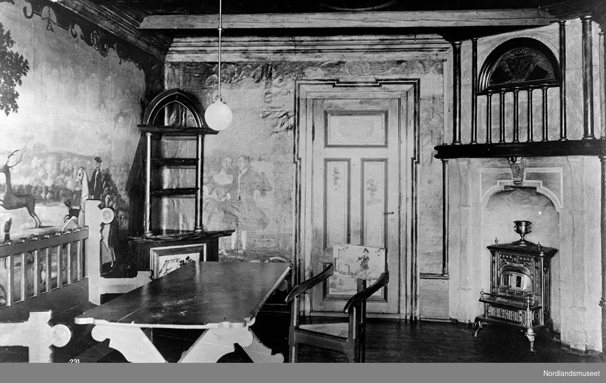 Ludvig Philip-værelset på Landbruksskolen. Et rom med bord og stoler. En kamin står i et hjørne. Mange malerier og utskjæringer på veggene.