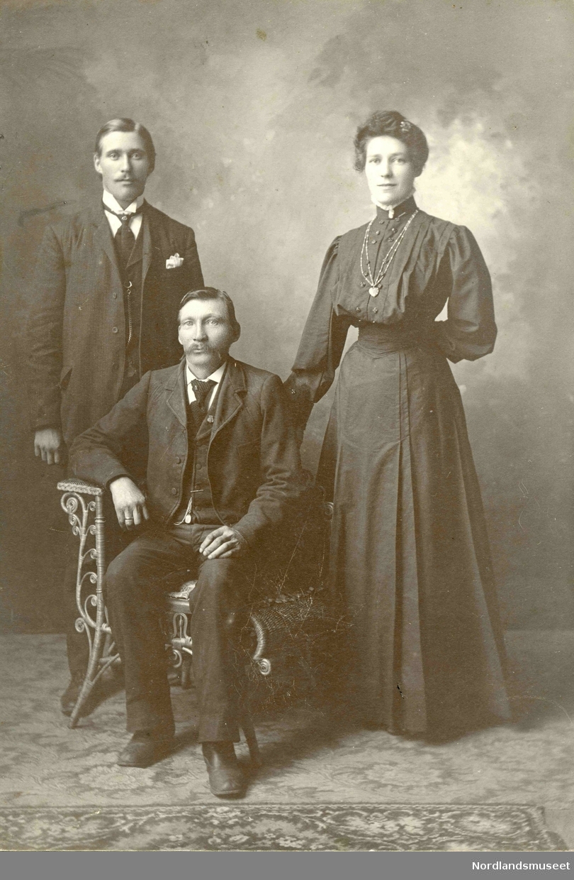 Portrett av tre mennesker. Stående Johan Kristian Jentoft Sommernes  (1880) og Aminde Olsen (1879). Sittende er Adolf Olsen (1876), bror til Aminde.