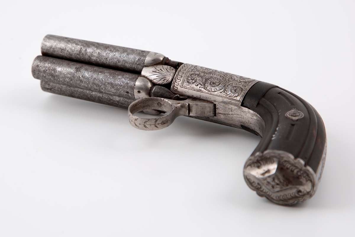 Fireløpet pistol, såkalt pepperboxpistol, hvor stålet er dekorert med siselert bladdekor. Skjeftet er i ibenholt.