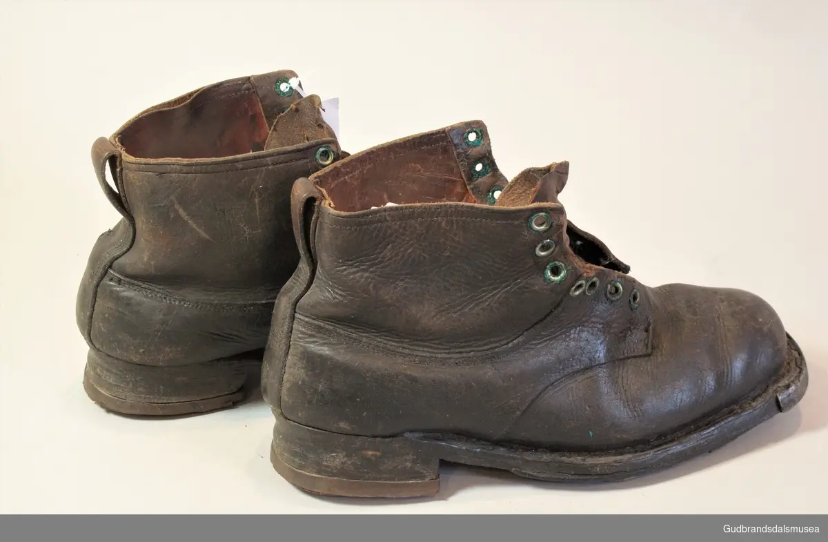 Randsydd beksømstøvle i kraftig skinn med fot og hæler opprinnelig i lær. Str. 44,5. Seinere påsatt hæler av gummi. Hæler med spor for skibinding. Beksømstøvlen var vanlig som skistøvle til inn på 1960-tallet. Men i dette tilfellet er støvlen av brukeren seinere gjort om til en turstøvle med hæl-, og tåjern, kantspiker og midtsålspiker for bedre fotfeste. Lukkes med snøring.