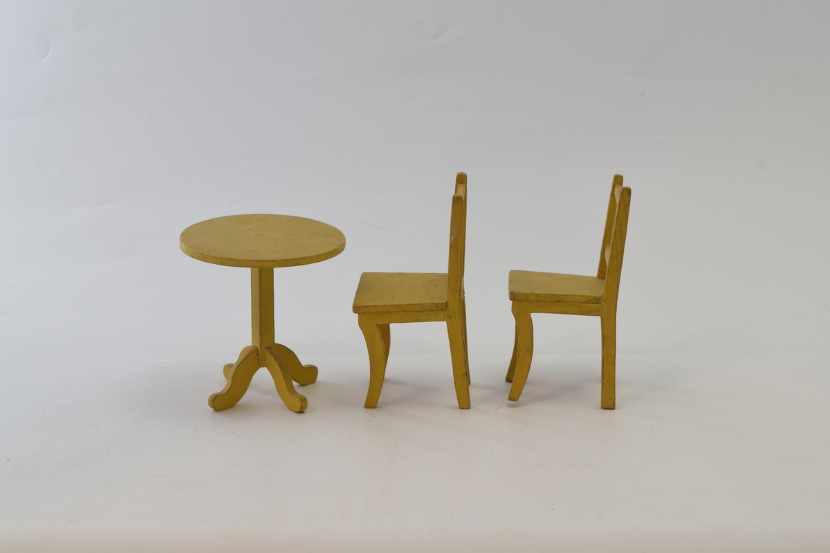 Spisestuemøblement i tre. Detaljrikt arbeid med avrundede bordbein og kurvede bein på stolene. Den ene stolen ahr fått et nytt bakbein.