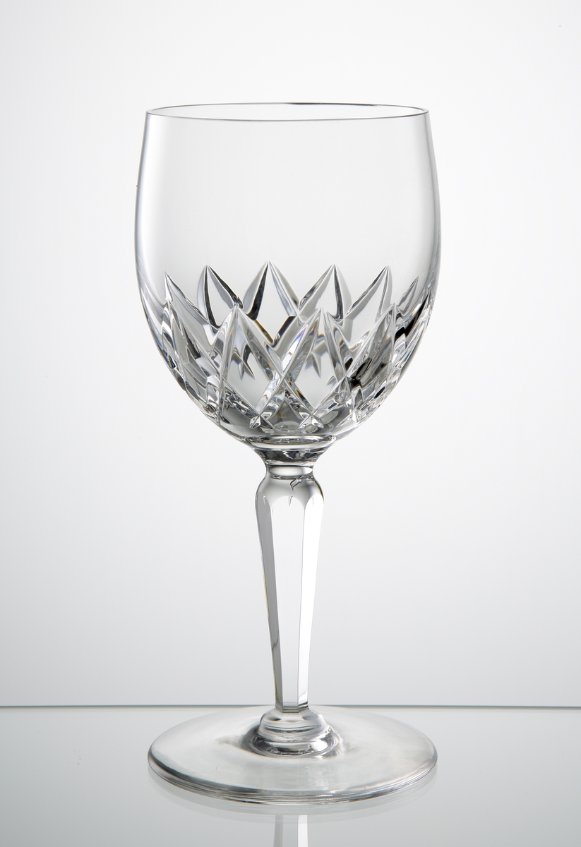 Design: Ingeborg Lundin.
Ölglas (goblet), närmast klotformad kupa med skärslipad dekor på kupans nedre del. Fasettslipat balusterben på slät fot.