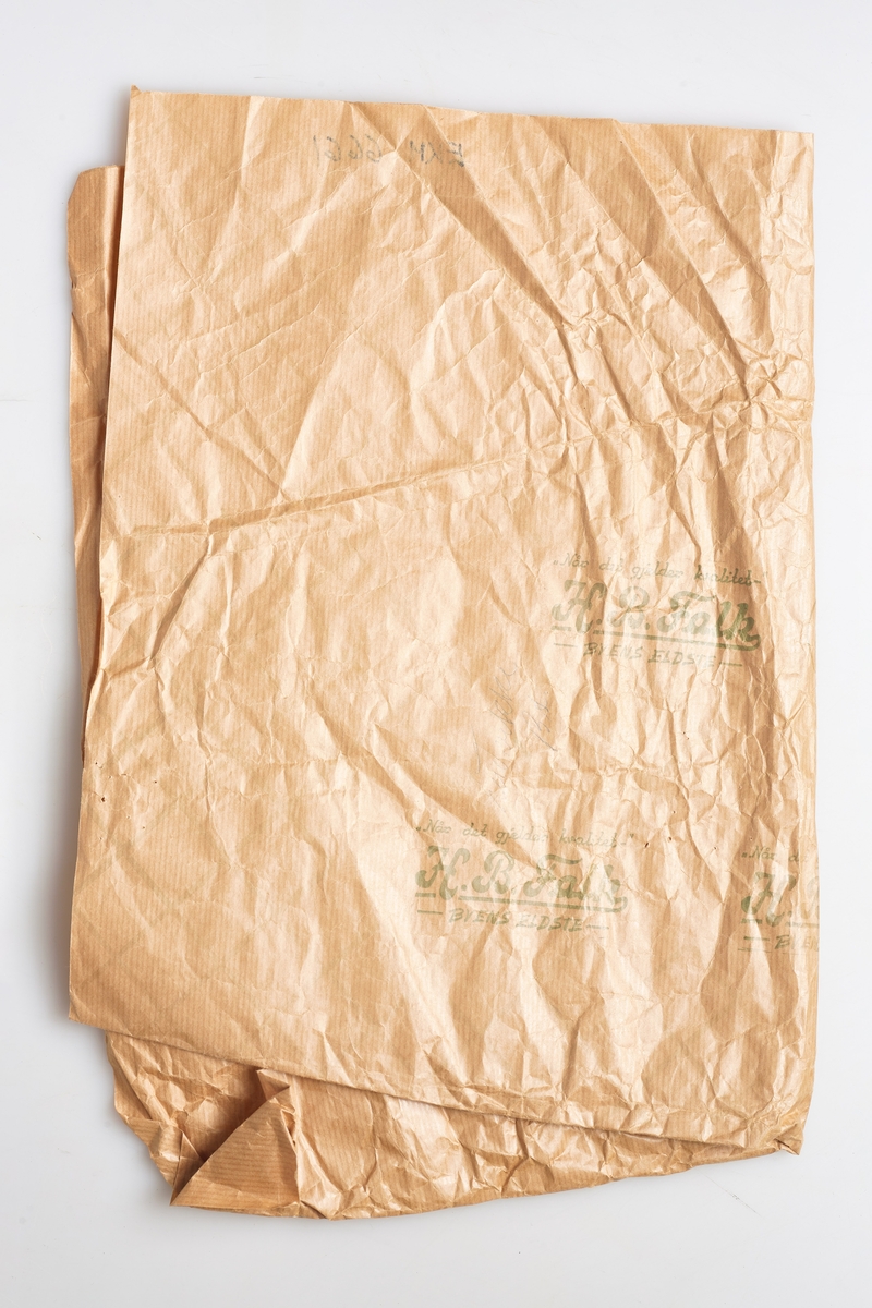 Gråpapir til innpakking, med påtrykket grønn skrift og rutemønster. 
