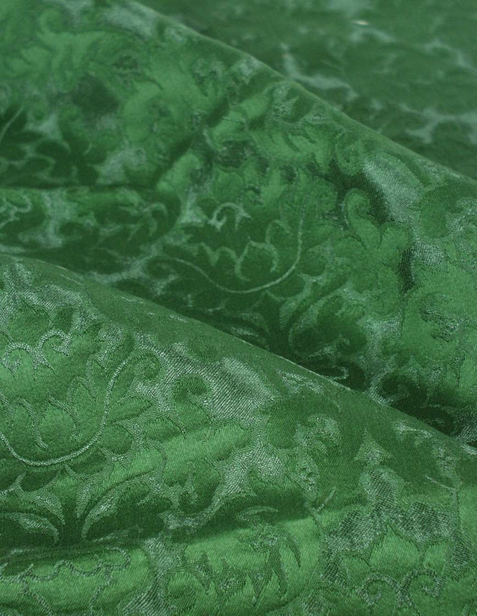 Vevd stoffrest til møbler. Grønn farge med stilistisk blomster- og bladdekor.