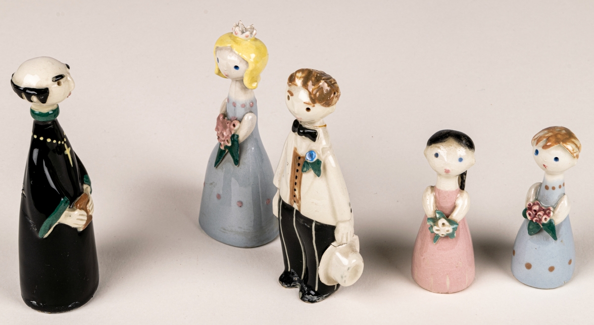 Brudfölje om fem figuriner: präst, brud, brudgum och två tärnor. Formgivare Dorothy Clough, 1955, Gefle Porslinsfabrik.
Prästen är 10 cm hög, bruden 9,5 cm, brudgumen 10 cm, näbbarna 6,7 cm.