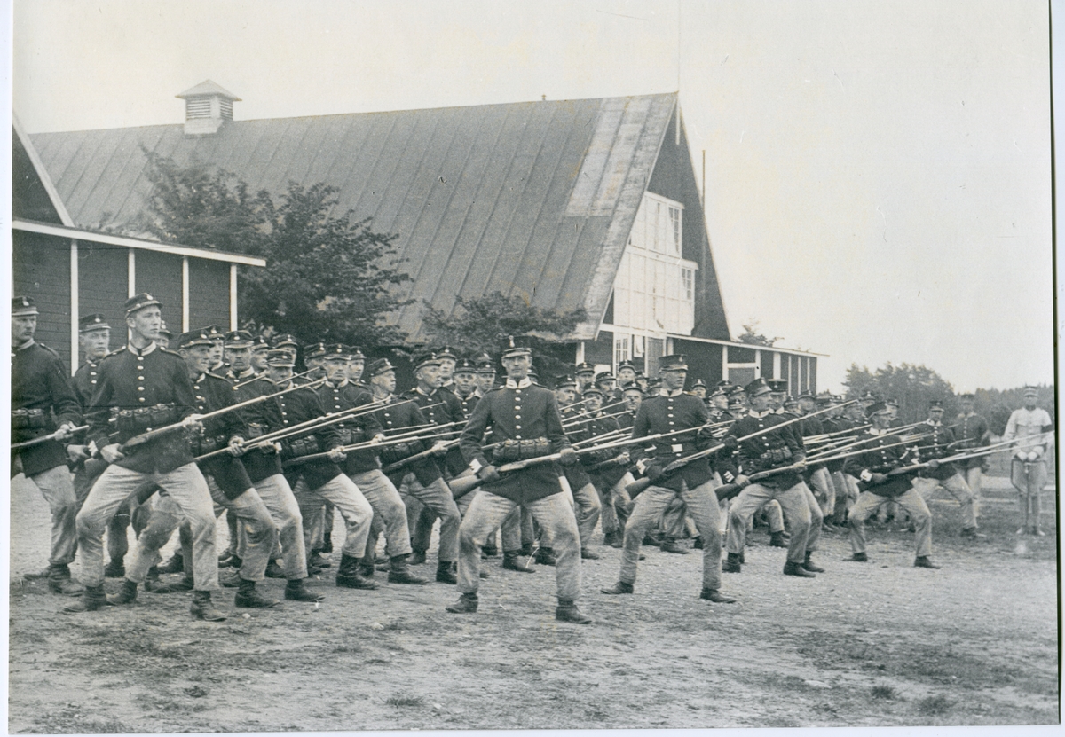 Malmen 1910-tal. Stor militärgrupp gör exercis med remingtongevär.
