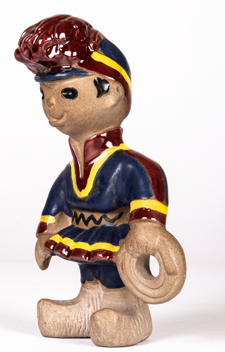 Figurin Lappojke, formgiven av Dorothy Clough 1955, vid Gefle Porslinsfabrik. Hör samman med figurinerna Lappflicka och Lapphund.