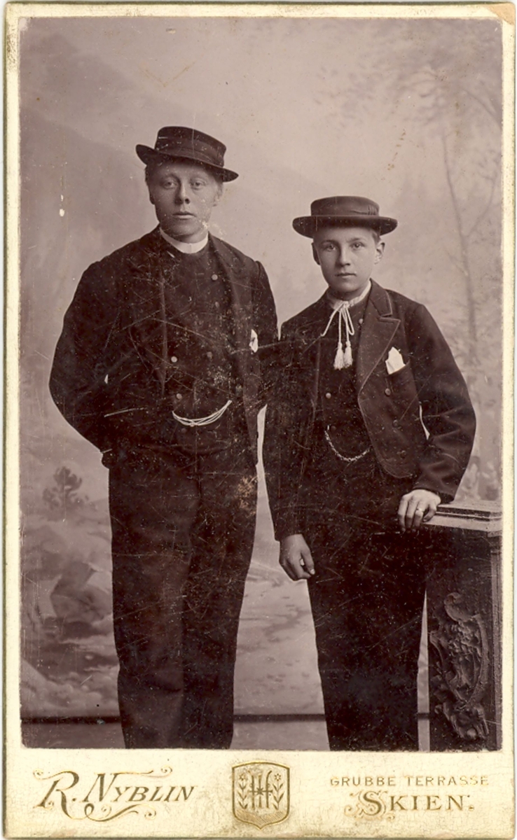 To yngre menn fotografert i atelier
T.v. Kittil Vatnar og t.h. Halvor O. Vreim.
Visittkortbilde.
Fotograf: R. Nyblin, skien
NB: Bak på det eine bildet står det namnet Olav Li stiden for Halvor Vreim.